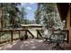 Relaxing deck area with outdoor seating and a view of the expansive backyard and surrounding trees at 29101 Drexel Spur, Evergreen, CO 80439