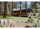 Picturesque view of a home in a wooded setting with a deck, offering a tranquil escape amidst nature at 29101 Drexel Spur, Evergreen, CO 80439