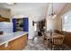 Open kitchen showcases island, pantry with blue curtain, and a dining area with wood table and chairs at 29101 Drexel Spur, Evergreen, CO 80439