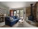Cozy living room with a stone fireplace, a comfortable blue sofa, and views of the outdoor scenery at 29101 Drexel Spur, Evergreen, CO 80439