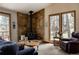 Inviting living room featuring a rustic stone fireplace and picture windows with lovely wooded views at 29101 Drexel Spur, Evergreen, CO 80439