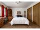 Bright bedroom with wood furnishings, white bedding, and ample closet space with wood doors at 29101 Drexel Spur, Evergreen, CO 80439