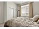 Bright bedroom with a large window dressed with curtains and venetian blinds for controlling natural light at 12258 Hazel Spruce Ct, Parker, CO 80134