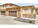Townhome with a two-car garage featuring a stone facade and a private entrance at 12258 Hazel Spruce Ct, Parker, CO 80134