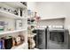 Well-organized laundry room featuring built-in shelves and modern washer and dryer at 12258 Hazel Spruce Ct, Parker, CO 80134