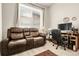 Comfortable living room featuring a reclining couch and a large window at 12258 Hazel Spruce Ct, Parker, CO 80134