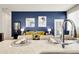Open living space with blue accent wall, modern decor, and a connection to the kitchen at 12258 Hazel Spruce Ct, Parker, CO 80134