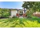 Home with a well-manicured lawn and a wood deck for outdoor relaxation and entertainment at 6303 E Dakota Ave, Denver, CO 80224