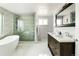 Modern bathroom featuring a freestanding tub, glass-enclosed shower, and a double sink vanity at 6303 E Dakota Ave, Denver, CO 80224