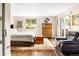Bright bedroom featuring hardwood floors, neutral walls, and a sliding glass door to a deck at 6303 E Dakota Ave, Denver, CO 80224