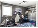 Home gym includes exercise bikes, storage shelves, a bench, and natural light at 6303 E Dakota Ave, Denver, CO 80224