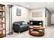 Cozy seating area with a gray sofa, round coffee table, and decorative artwork at 6303 E Dakota Ave, Denver, CO 80224