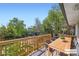 A spacious wooden deck featuring an outdoor dining area surrounded by lush greenery and a pergola at 8897 Wagner Ln, Westminster, CO 80031