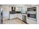 Modern kitchen with white cabinets, stainless steel appliances, stylish backsplash, and hardwood flooring at 8897 Wagner Ln, Westminster, CO 80031