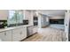 Bright kitchen featuring stainless steel appliances, white cabinetry, and hardwood floors adjacent to a living space at 8897 Wagner Ln, Westminster, CO 80031