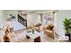 Staged living room with wood floors, bay window, staircase, and modern furnishings at 8897 Wagner Ln, Westminster, CO 80031