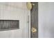 Elegant shower featuring modern tile, rain shower head, and built-in storage niche at 8897 Wagner Ln, Westminster, CO 80031