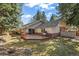 Home's backyard featuring a wooden deck, lush green lawn and tall trees at 4862 Silver Sage Ct, Boulder, CO 80301