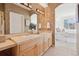 Bathroom with double sinks, wallpaper, and view into the well-lit primary bedroom at 1747 N Washington St # C306, Denver, CO 80203