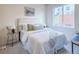 Bedroom featuring comfortable bed with plush bedding, side table, and large window at 1747 N Washington St # C306, Denver, CO 80203