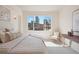 Bright bedroom featuring city views, comfortable bed, chair, and side table for relaxation at 1747 N Washington St # C306, Denver, CO 80203