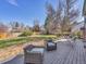 Backyard deck featuring patio seating, surrounded by mature trees and beautiful landscaping at 3766 E Easter S Cir, Centennial, CO 80122