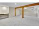Partially finished basement with carpeting, exposed beams and built-in shelving at 3766 E Easter S Cir, Centennial, CO 80122