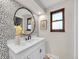 Stylish bathroom with a vanity, round mirror, and unique patterned wallpaper at 3766 E Easter S Cir, Centennial, CO 80122