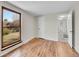 Sunlit bedroom featuring hardwood floors, a large window, and a bright hallway at 3766 E Easter S Cir, Centennial, CO 80122
