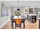 A dining room is shown with art and a view to an updated kitchen at 3766 E Easter S Cir, Centennial, CO 80122