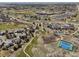 Expansive aerial view of a residential neighborhood with golf course, tennis courts, and community buildings at 21231 E Saddle Rock Ln, Aurora, CO 80016