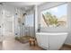 Bright bathroom featuring a freestanding tub, separate glass enclosed shower, and a window providing natural light at 21231 E Saddle Rock Ln, Aurora, CO 80016