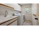 Bright laundry room with modern washer, dryer, sink, and storage cabinets at 21231 E Saddle Rock Ln, Aurora, CO 80016