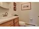 Cozy half bathroom with wood cabinets, modern fixtures, and art-adorned walls at 2378 Hearth Dr # 6, Evergreen, CO 80439