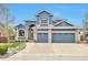 Inviting home boasts a two-car garage, manicured lawn, and stylish blue exterior at 9371 Desert Willow Trl, Highlands Ranch, CO 80129