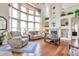 Spacious living room with hardwood floors, a fireplace, and large windows providing ample natural light at 9371 Desert Willow Trl, Highlands Ranch, CO 80129