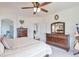 Bright main bedroom featuring a ceiling fan and wooden dresser at 9371 Desert Willow Trl, Highlands Ranch, CO 80129