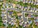 An aerial view shows houses nestled on a cul-de-sac neighborhood street with lush trees and green landscaping at 9620 Mallard Pond Way, Littleton, CO 80125
