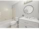 Bright bathroom features a tub and shower combo, vanity with a round mirror, and decorative plant at 9620 Mallard Pond Way, Littleton, CO 80125