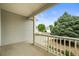 Covered front porch with white railings and view of landscaped yard at 9620 Mallard Pond Way, Littleton, CO 80125