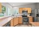 Kitchen featuring stainless steel appliances, generous counter space, and hardwood floors at 9620 Mallard Pond Way, Littleton, CO 80125