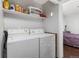 Practical laundry room equipped with appliances and shelving for organized storage at 8260 Washington St # 78, Denver, CO 80229