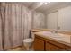 Bathroom featuring a shower/tub combo, a vanity and neutral patterned shower curtain at 3414 S Eagle St # 201, Aurora, CO 80014