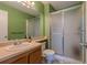 Bathroom featuring a step-in shower with glass doors, vanity, and sink at 3414 S Eagle St # 201, Aurora, CO 80014