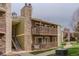 Two story exterior view of condo building with balconies and a stone chimney at 3414 S Eagle St # 201, Aurora, CO 80014