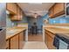 Galley kitchen with wood cabinets, laminate countertops, open to dining area at 3414 S Eagle St # 201, Aurora, CO 80014
