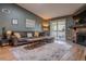 Living room with a fireplace, modern rug, and access to the balcony at 3414 S Eagle St # 201, Aurora, CO 80014