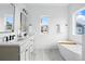 Modern bathroom features double sinks, a soaking tub, and a window with views of the neighborhood at 924 Sunflower St, Louisville, CO 80027