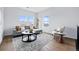 Bright living room boasts hardwood floors, plentiful windows, and a gray couch with decorative pillows at 924 Sunflower St, Louisville, CO 80027