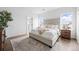 Bright main bedroom featuring a tufted headboard, plush bedding, and natural light from the windows at 924 Sunflower St, Louisville, CO 80027